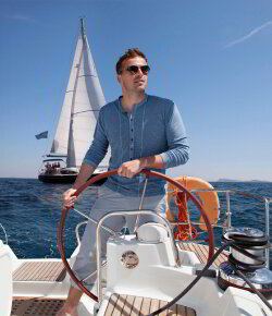 Skipper steering a sailboat at the wheel