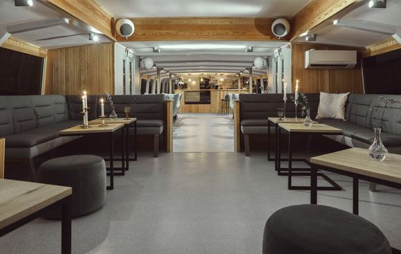 Yacht saloon with leather seating and candlelit tables